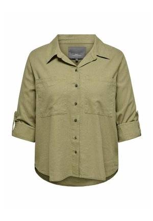 Camisa verde oliva de botón, hecha de una tela suave, con cuello, dos bolsillos frontales, mangas enrollables y un dobladillo redondeado.