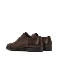 Chaussures en cuir marron à lacets avec bout arrondi, texture lisse, petit talon et détail de couture discret. Design épuré et minimaliste.
