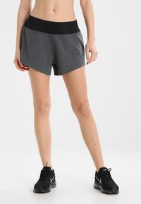 Grijze sportshorts met een zwarte tailleband; heeft een zachte, gestructureerde stof en een moderne snit, ontworpen voor actieve kleding.