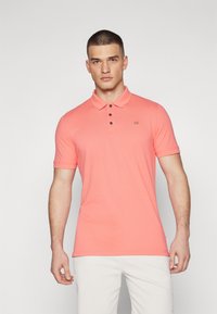 Morské polo tričko s krátkym rukávom v koralovej farbe, s golierom, trojpo_buttonovou légou a logom CK na hrudi. Mäkka, hladká textúra.
