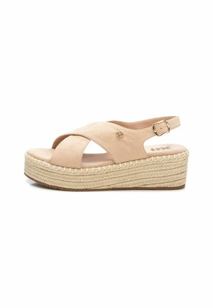 Sandalia de ante beige con tiras cruzadas y hebilla ajustable en el tobillo. Presenta una suela de cuña envuelta en yute para mayor altura y estabilidad.