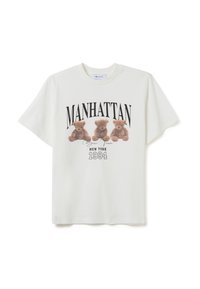 T-shirt bianco in cotone con una grafica di tre orsetti marroni e la scritta "MANHATTAN" e "NEW YORK 1994" in nero. Maniche corte.