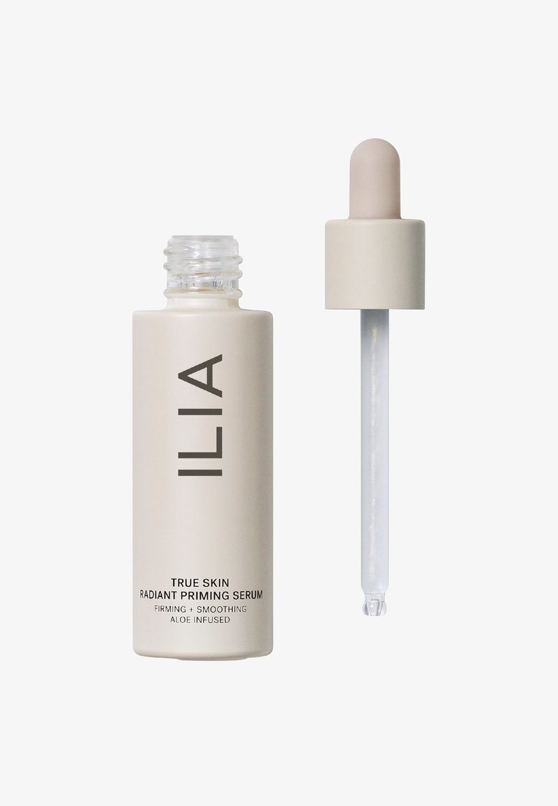 ILIA True Skin Radiant Priming Serum i en frostet glassflaske med en beige etikett, som har en pipettekork og klar serum.