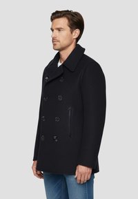 Manteau en laine noire de style caban avec un design croisé, grand col et boutons brillants. Comprend une poche latérale et une coupe décontractée.