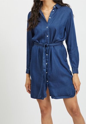 Robe chemise en denim bleu foncé, avec fermeture boutonnée à l'avant, manches longues, taille ceinturée et longueur au genou.