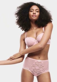 Lichtroze lingerieset met een bh met beugel en kantafwerking en een hoge taille slip met een kanten paneel en knoopdetail.