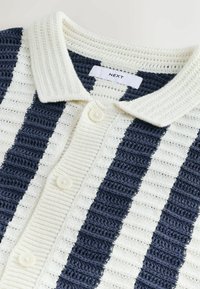 Cardigan tricotat cu guler, cu dungi verticale largi bleumarin și albe, nasturi în față și textură ribată.