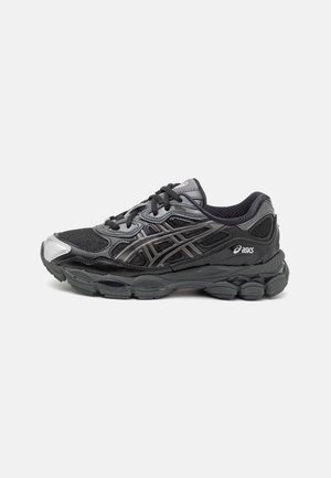 Zwarte en grijze ASICS hardloopschoen met mesh en synthetische bovenkant, dikke gedempte zool en logo aan de zijkant, getoond vanaf de buitenzijde.