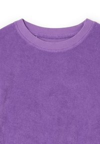 Gros plan sur un t-shirt en éponge violet à col rond, montrant la texture et les coutures autour de l'encolure sur un fond blanc.