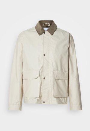 Vaaleanbeige takki, jossa on ruskea samettikaulus, kaksi etutaskua, nepparikiinnitys ja sileä pinta. Rentoa muotoilua, joka soveltuu kerrospukeutumiseen.