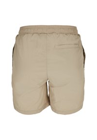 Shorts décontractés beige pour homme avec taille élastiquée, poche passepoilée arrière et poches latérales, vus de dos sur fond blanc.