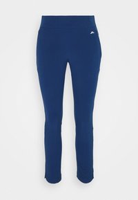 Blå tajta träningsbyxor med hög midja och liten vit Logotyp på övre vänstra höften, visade på vit bakgrund.