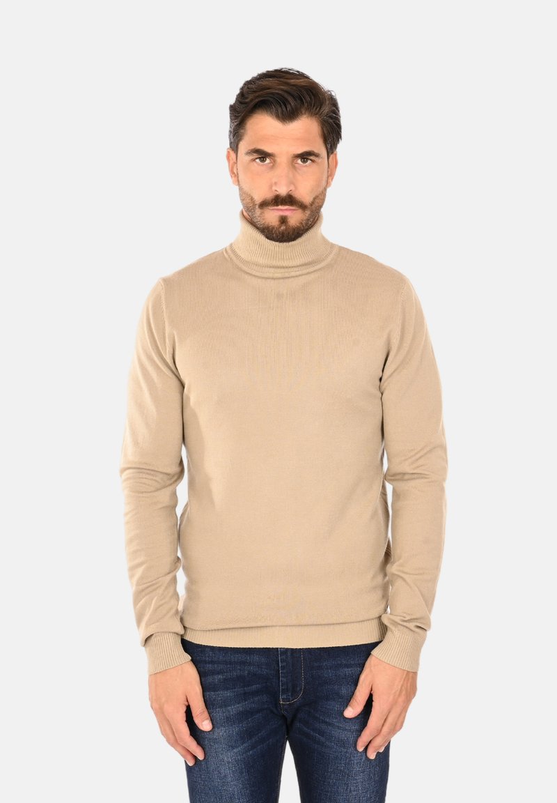 Maglione beige a collo alto, tessitura a coste, design attillato, maniche lunghe, abbinato a jeans blu per un look casual.