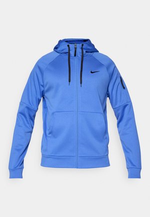 Mėlyna Nike zip-up džemperis su juodomis raištelėmis, šoniniais kišenėmis, kišenė ant rankovės su užtrauktuku ir juodu Nike logotipu ant krūtinės.