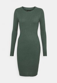 Tmavě zelené žebrované úpletové šaty s dlouhým rukávem, těsně přiléhajícího střihu a kulatým výstřihem, vystavené na bílém pozadí.
