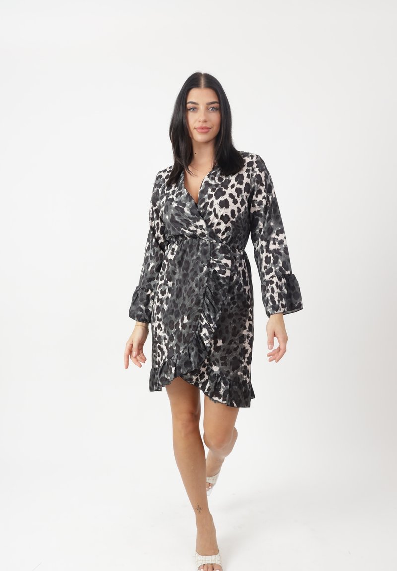 Leopardenmuster-Wickeldress in Schwarz und Nude mit Rüschensaum und langen Ärmeln. Hergestellt aus leichtem Stoff und verfügt über einen tiefen V-Ausschnitt.