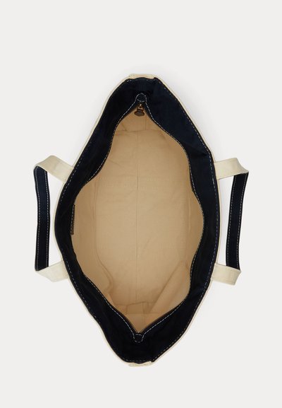 Geantă tote din pânză cu margini și mânere negre, interior bej și închidere cu fermoar, văzută de sus cu geanta deschisă.