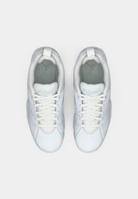 Ein Paar weiße Leder-Sneaker mit Schnürsenkeln, grauen Einlegesohlen und Zugschlaufen auf einem schlichten weißen Hintergrund, von oben betrachtet.