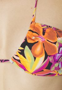 Góra bikini z intensywnym nadrukiem kwiatowym w odcieniach pomarańczowego i fioletowego. Wykonana z elastycznego materiału, posiada cienkie regulowane ramiączka oraz marszczone szwy.