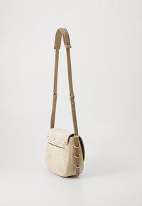 Borsa a tracolla in suede beige con tracolla in pelle regolabile, hardware in metallo e tasca frontale sotto la chiusura a scatto.