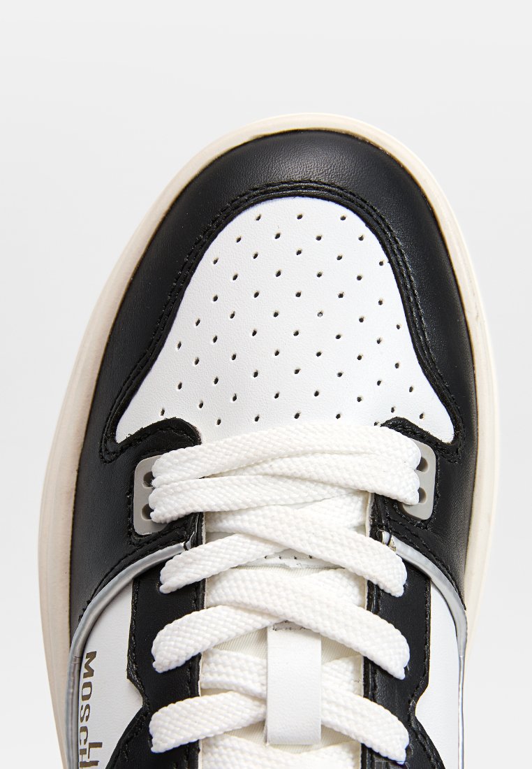 Scarpa da ginnastica in bianco e nero con punta traforata, pelle testurizzata, lacci bianchi e dettaglio logo sul lato.