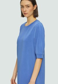 Blaues kurzärmliges Kleid mit rundem Ausschnitt, aus glattem Stoff gefertigt. Bietet eine lockere Passform und umgeschlagene Ärmel.