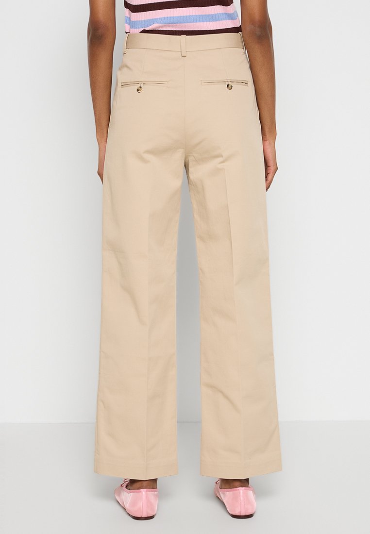 Pantaloni beige a gamba larga con vita alta, due tasche posteriori e chiusura con cerniera. Tessuto liscio con una vestibilità strutturata.