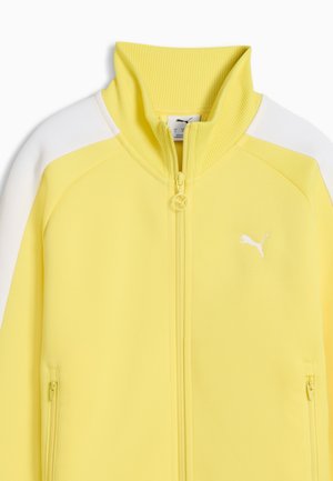 Gelbe und weiße Sportjacke zum Reißverschluss mit hohem geripptem Kragen, seitlichen Reißverschlusstaschen und kleinem Puma-Logo auf der Brust.