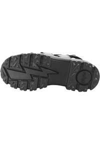 Black shoe sole with rugged, textured surface. Features zigzag pattern and triangular treads for traction, marked with the brand logo.