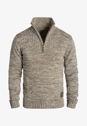 Pletena pulover u svijetlosmeđoj i krem boji s visokim ovratnikom, polu-zatvaračem, rebrastim rukavima i donjim dijelom, koji ima teksturirani uzorak i logotip.