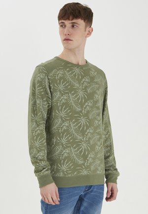 Groene sweatshirt met een bladerenpatroon, ronde hals en ribgebreide manchetten. Gemaakt van zacht materiaal, met een relaxte pasvorm en raglanmouwen.