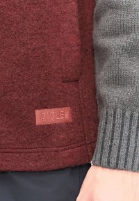 Bordeaux uldblandet jakke med en tekstureret finish, detaljeret lomme og mærke; parret med en ribbet grå strikket ærme.