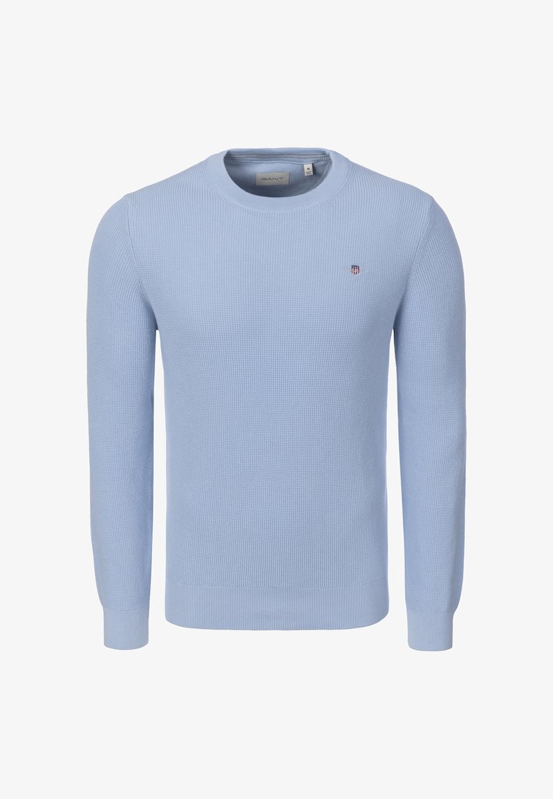 Pull texturé bleu clair à manches longues avec col rond, poignets et ourlet côtelés, et petit logo brodé sur la poitrine gauche.