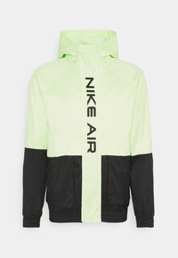 Nike Air-jacka i neongrön och svart. Lätt material med dragkedja fram, långa ärmar och logotyp tryckt vertikalt på bröstet.