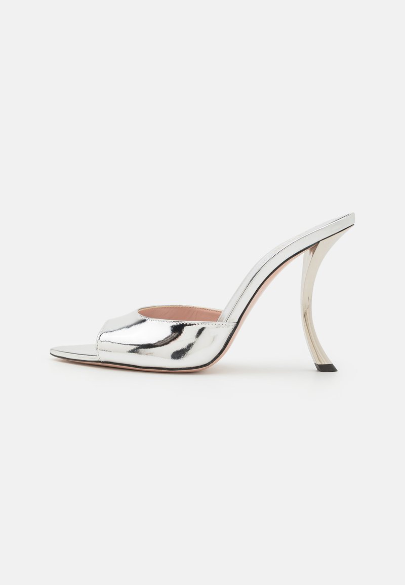 Mule argentato metallizzato con tacco alto, aperto davanti, tacco curvo e texture liscia; presenta un design minimalista e una leggera variazione di colore.