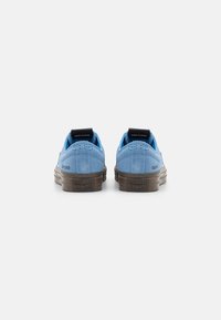 Sneaker in suede blu chiaro con un design a profilo basso, dotati di suole in gomma marrone e linguette sul tallone nere con logo.