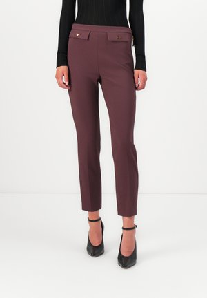 Maroon tailored pants with a smooth texture, featuring two front flap pockets, gold-tone accents, and slim fit design tapering to the ankle.