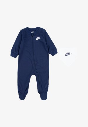 Tmavě modrý bavlněný dětský overal s dlouhými rukávy, na zip a s bílým logem Nike. Součástí je také odpovídající bílá šátek s logem.
