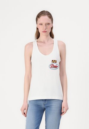 White cotton tank top with a scooped neckline, featuring a red and blue embroidered patch that reads "Pink Garage." Simple, casual design.