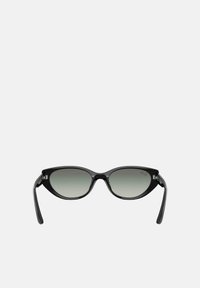 Occhiali da sole neri a forma di occhio di gatto con lenti sfumate e montatura in plastica lucida. Presentano aste sottili e un sottile dettaglio del logo sulla lente.