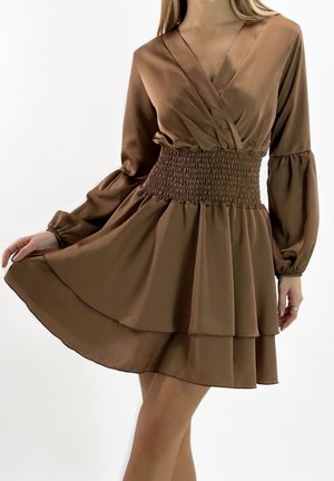 Brązowa sukienka z satyny z głębokim dekoltem w serek, marszczoną talią i długimi rękawami. Posiada warstwową, rozkloszowaną spódnicę zapewniającą zwiewną sylwetkę.