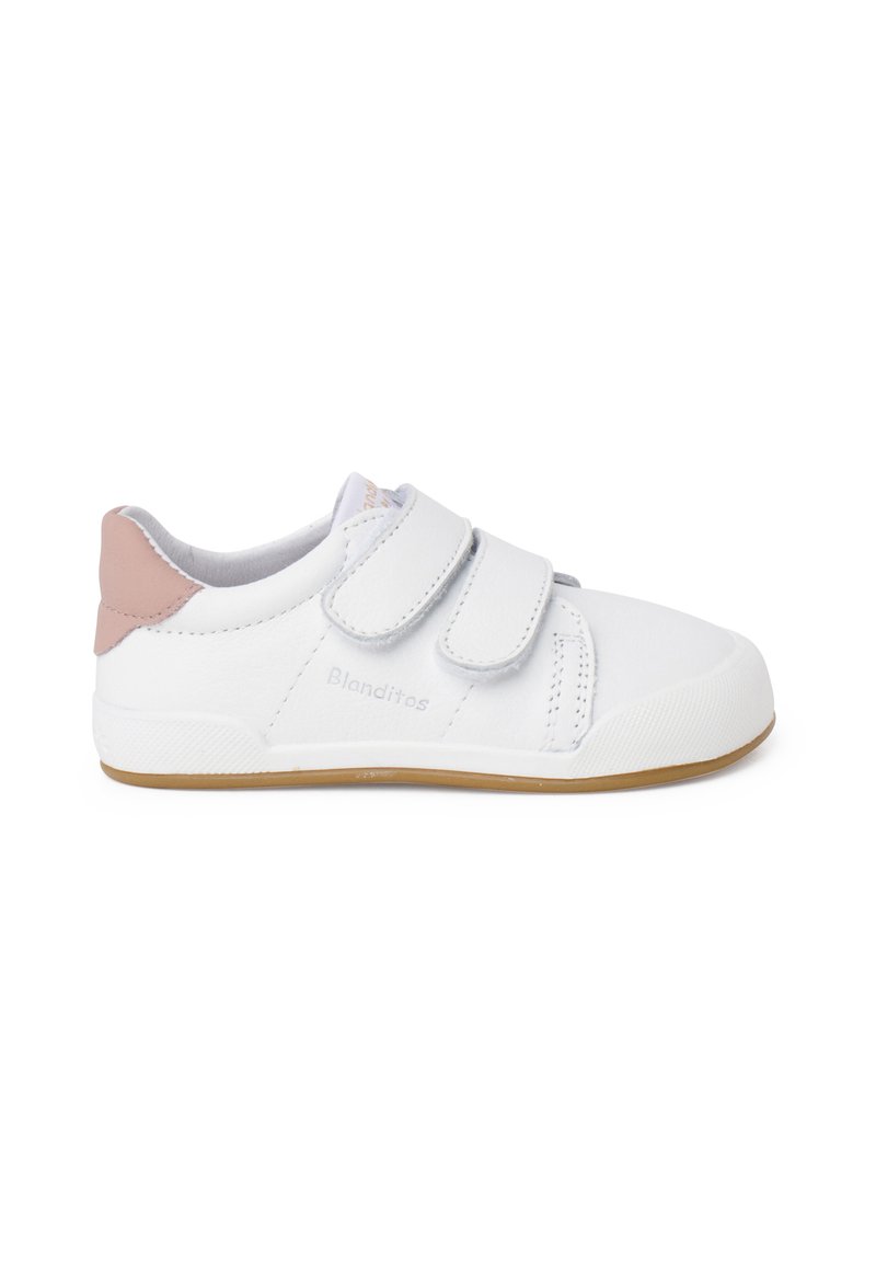 Scarpa in pelle bianca con due cinturini in Velcro, accentuata da un tacco rosa chiaro, suola in gomma e dettagli testurizzati di lato. Nome del marchio "Blanditos" visibile.