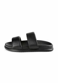 Zwarte slide-sandalen met twee brede banden, gemaakt van een gestructureerd materiaal. Beschikken over een platte zool en een glad voetbed voor comfort.