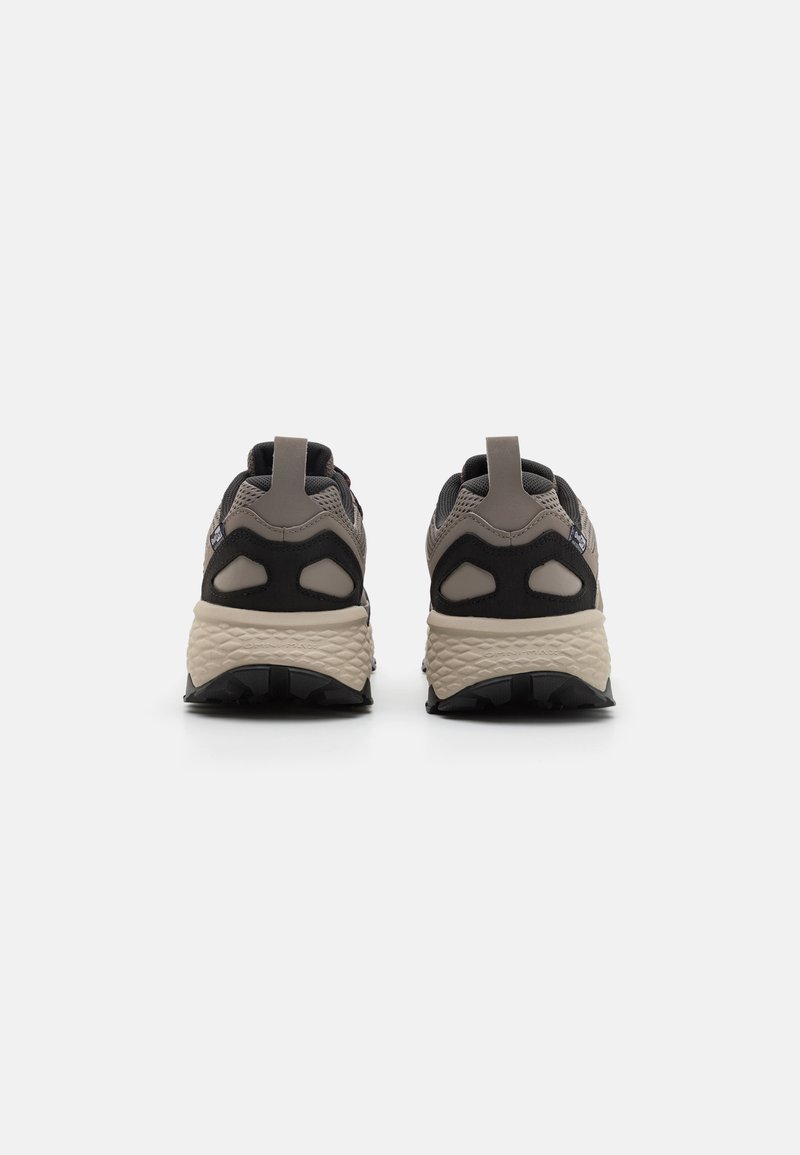 Chunky Sportb Schuhe in Grau und Schwarz, mit einer strukturierten Oberfläche, verstärktem Absatz und einer robusten Sohle mit ausgeprägtem Profilmuster.