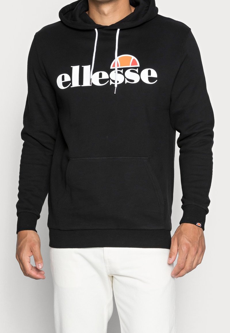 Sudadera negra con logo blanco de "ellesse", bolsillo frontal, capucha con cordones, puños y dobladillo acanalados. Hecha de una tela suave, con corte relajado.