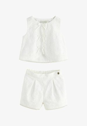 Ensemble blanc composé d'un haut sans manches et d'un short avec broderie florale, bordure en dentelle et nœuds à l'avant, conçu pour les jeunes enfants.