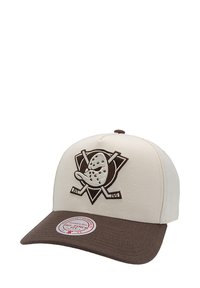 Beige baseball cap with a brown visor, featuring an embroidered logo of a cartoon duck and crossed hockey sticks on the front.