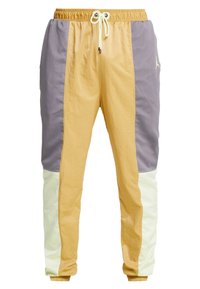 Leichte Jogginghosen mit einem Farbblock-Design in Gelb, Grau und Creme; ausgestattet mit atmungsaktiven Mesh-Einsätzen und einem elastischen Bund mit Kordelzug.