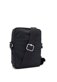 Black nylon crossbody bag with a square shape, featuring a zip closure, adjustable strap, and a pom-pom accent on the side.