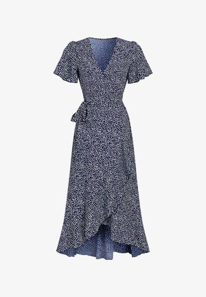 Marineblauwe wikkeljurk met wit stippenpatroon, korte ruches mouwen en een getailleerde taille met strik; heeft een vloeiende rok met een high-low zoom.